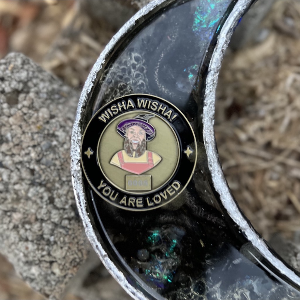 Side A of the wizard coin displayed inside a black and silver crescent moon dish.